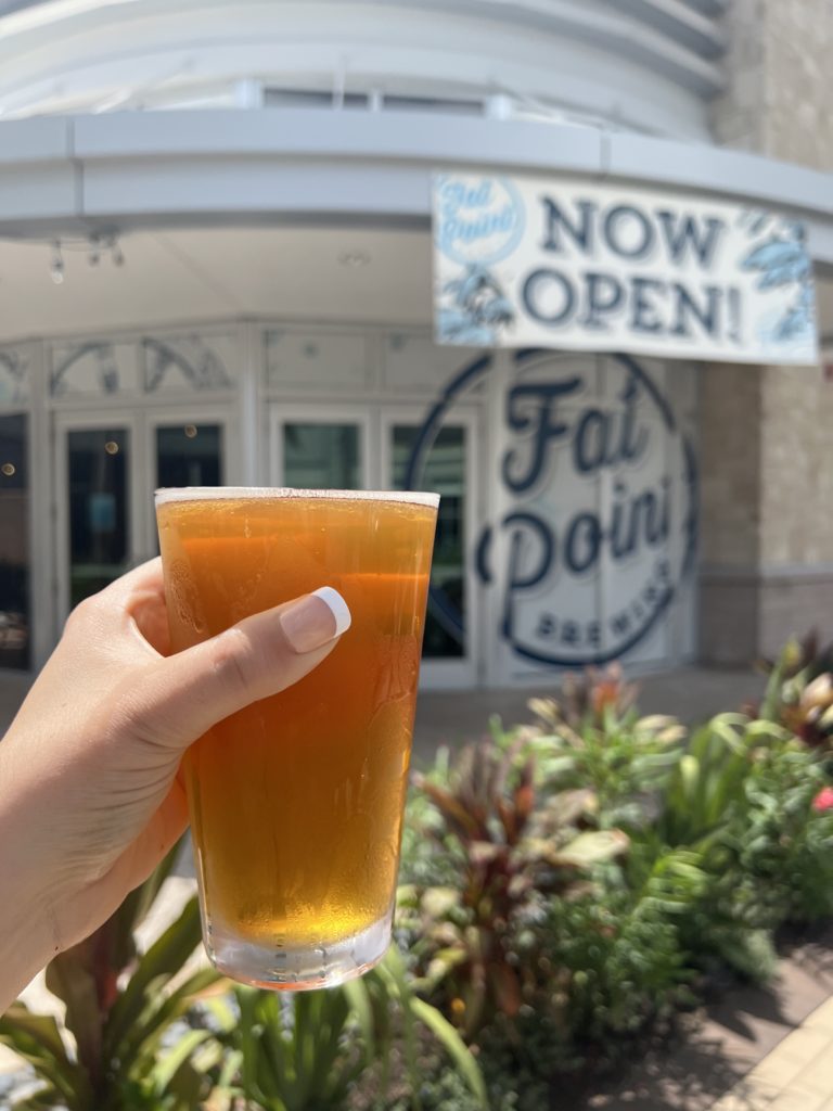 Glass of beer in front of Fat Point UTC Grand Opening